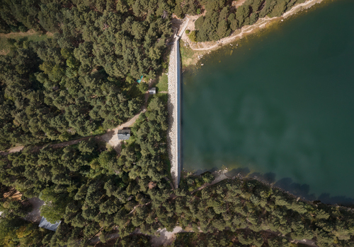 Aerial view of Lake Engolasters surrounded by dense pine forests and a stone dam Encamp Andorra. Aerial view of Lake Engolasters surrounded by dense pine forests and a stone dam Encamp Andorra.