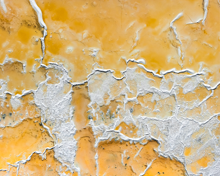 Aerial view of intricate cracked yellow and white mineral patterns on the ground in Redwood City California United States.
