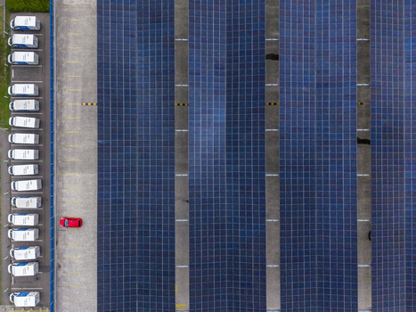 Aerial view of the solar panel canopy installation at the IKEA Eindhoven parking lot featuring a row of parked white delivery vans and a single red car in Son Noord Brabant Netherlands. Aerial view of the solar panel canopy installation at the IKEA Eindhoven parking lot featuring a row of parked white delivery vans and a single red car in Son Noord Brabant Netherlands.