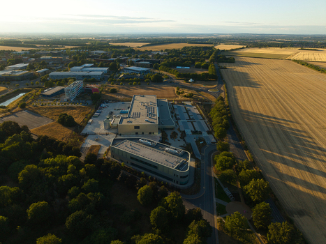 Aerial view of the Moderna Innovation and Technology Centre surrounded by fields trees and parking areas at the Harwell Science and Innovation Campus in Harwell Oxford England United Kingdom.
