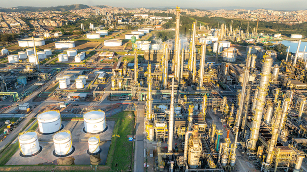 Aerial view of the petrochemical complex featuring industrial storage tanks and distillation towers set against an urban landscape in Santo Andre State of Sao Paulo Brazil.
