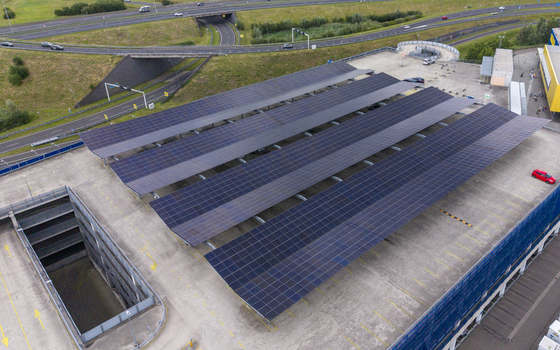 Aerial view of solar panel carports covering a parking lot at IKEA Eindhoven with a nearby highway and green landscape in Son Noord Brabant Netherlands. Aerial view of solar panel carports covering a parking lot at IKEA Eindhoven with a nearby highway and green landscape in Son Noord Brabant Netherlands.