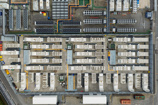 Aerial view of a data center facility featuring rows of white server containers cooling units and industrial infrastructure in the United Kingdom.
