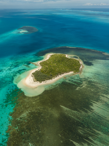 Aerial view of vibrant turquoise waters embrace lush green islands contrasting with the intricate patterns of coral reefs below Noumea New Caledonia. Aerial view of vibrant turquoise waters embrace lush green islands contrasting with the intricate patterns of coral reefs below Noumea New Caledonia.