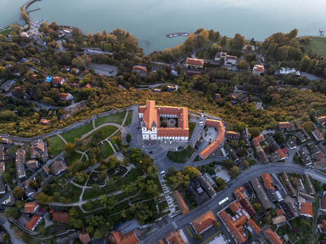Aerial view of Tihany Abbey surrounded by lush greenery historic rooftops and the scenic Lake Balaton in Tihany Hungary. Aerial view of Tihany Abbey surrounded by lush greenery historic rooftops and the scenic Lake Balaton in Tihany Hungary.
