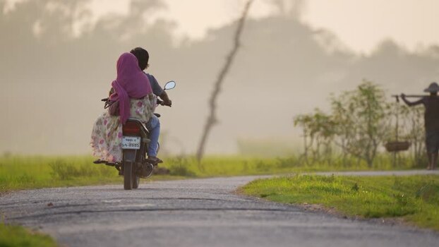 View of a couple on a motorcycle in rural Bogura Bangladesh.