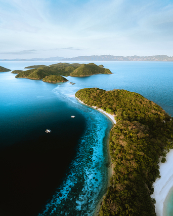 Aerial view of the tropical islands of Coron with lush green vegetation white sand beaches and turquoise waters in Coron Mimaropa Philippines.