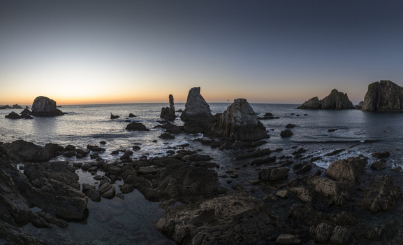 Aerial view of the dramatic rocky coastline and sea stacks at sunset in Nueva Asturias Spain.