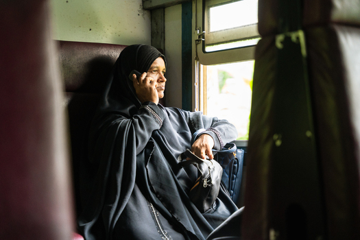 Sri Lanka 06 February 2026 View of a woman in a black hijab talking on a mobile phone while sitting by the window inside a train carriage.