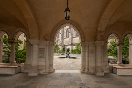 Washington District of Columbia United States 06 May 2025 View of Washington National Cathedral featuring a stone cloister with arched walkways a central fountain and lush greenery.