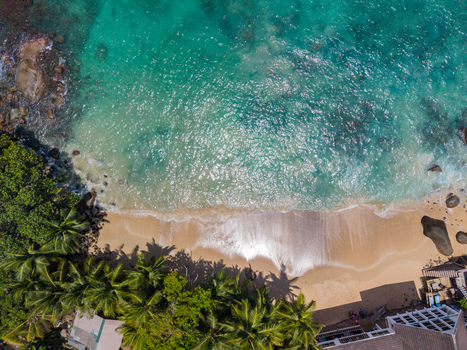 Aerial view of turquoise waters meet the sandy shore fringed by lush green palm trees creating a vibrant coastal scene Vista do Mar Mahe Island Seychelles. Aerial view of turquoise waters meet the sandy shore fringed by lush green palm trees creating a vibrant coastal scene Vista do Mar Mahe Island Seychelles.