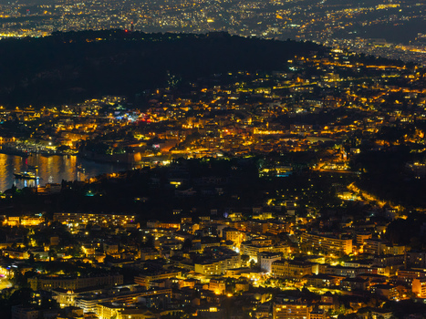 Aerial view of the illuminated hillside architecture and dense urban lights of the coastal town at night in Eze Provence Alpes Cote d Azur France. Aerial view of the illuminated hillside architecture and dense urban lights of the coastal town at night in Eze Provence Alpes Cote d Azur France.