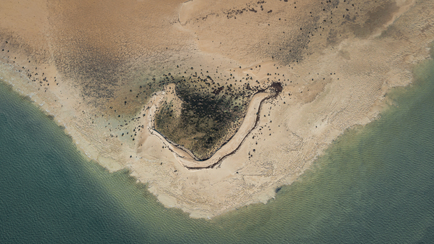 Aerial view of the coastline near Denham featuring intricate sand patterns turquoise waters and coastal vegetation in Denham Western Australia Australia. Aerial view of the coastline near Denham featuring intricate sand patterns turquoise waters and coastal vegetation in Denham Western Australia Australia.