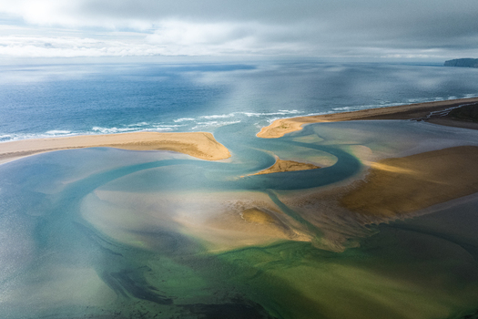 Aerial view of winding waterways meet the North Atlantic ocean on a cloudy day Rauðisandur Iceland. Aerial view of winding waterways meet the North Atlantic ocean on a cloudy day Rauðisandur Iceland.