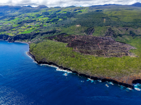 Aerial view of a rugged coastline where the deep blue sea meets the verdant land near Miradouro Prainha Pico Azores Portugal. Aerial view of a rugged coastline where the deep blue sea meets the verdant land near Miradouro Prainha Pico Azores Portugal.