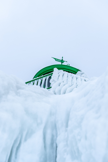 View of the Molenfeuer Sassnitz lighthouse covered in thick layers of ice and snow during a cold winter day in Sassnitz Mecklenburg Vorpommern Germany.