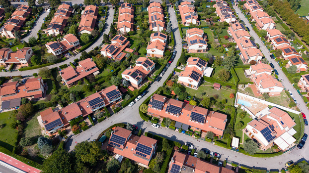 Aerial view of private houses with solar panels on rooftops surrounded by green gardens and residential streets in Mediglia Lombardy Italy. Aerial view of private houses with solar panels on rooftops surrounded by green gardens and residential streets in Mediglia Lombardy Italy.