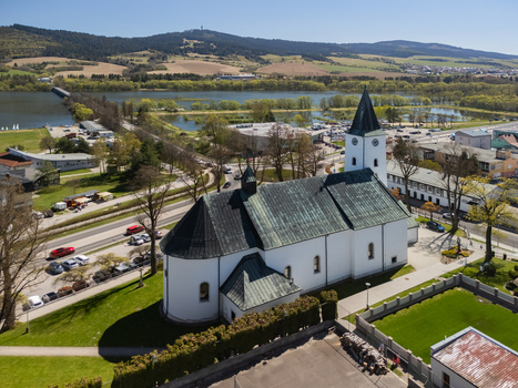 Aerial view of the Roman Catholic Church of Saints Simon and Jude with its white walls and green roof overlooking the Orava Reservoir and hills in Namestovo Zilina Region Slovakia. Aerial view of the Roman Catholic Church of Saints Simon and Jude with its white walls and green roof overlooking the Orava Reservoir and hills in Namestovo Zilina Region Slovakia.