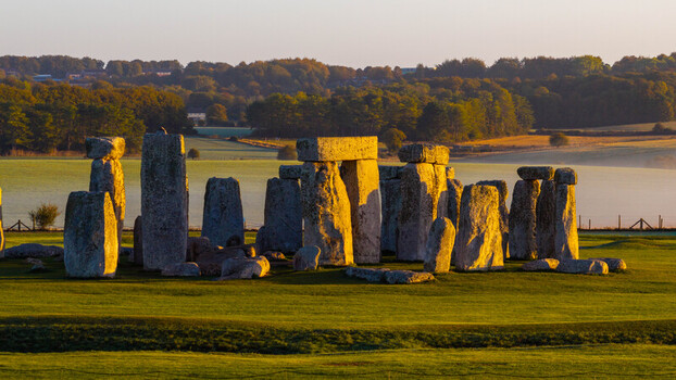 Aerial view of Stonehenge the prehistoric monument illuminated by golden hour sunlight in the green fields of Salisbury England United Kingdom. Aerial view of Stonehenge the prehistoric monument illuminated by golden hour sunlight in the green fields of Salisbury England United Kingdom.