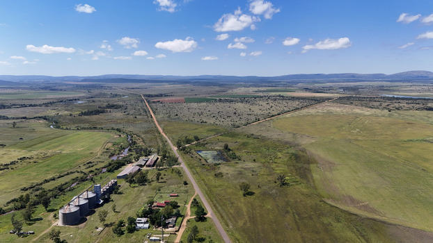 Aerial view of the rural landscape of Alma featuring grain silos farm buildings and a long straight road in Waterberg District Municipality Limpopo South Africa. Aerial view of the rural landscape of Alma featuring grain silos farm buildings and a long straight road in Waterberg District Municipality Limpopo South Africa.