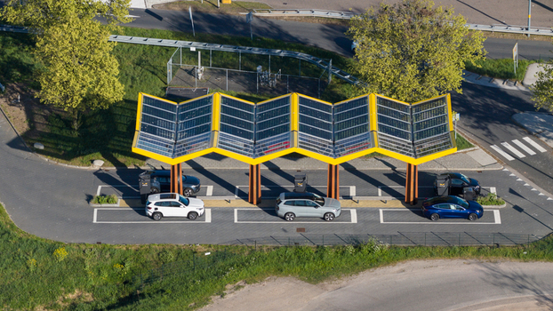 Bant Netherlands 23 April 2026 Aerial view of Fastned Charging Station with its iconic yellow zig zag solar roof and electric vehicles parked in charging bays surrounded by green trees. Bant Netherlands 23 April 2026 Aerial view of Fastned Charging Station with its iconic yellow zig zag solar roof and electric vehicles parked in charging bays surrounded by green trees.