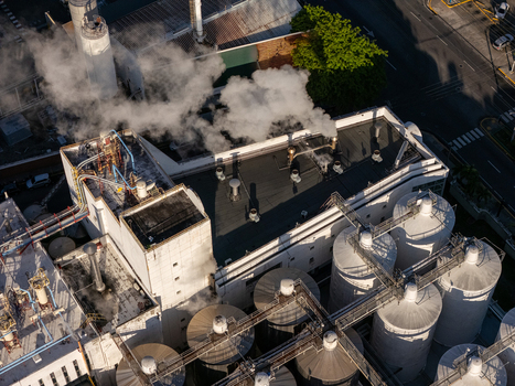 Aerial view of the beer industrial complex with large storage tanks industrial piping and steam rising from the rooftop in Santo Domingo Dominican Republic. Aerial view of the beer industrial complex with large storage tanks industrial piping and steam rising from the rooftop in Santo Domingo Dominican Republic.