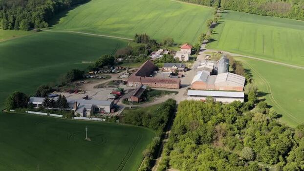 Aerial view of a farm complex and green fields in Czechia. Aerial view of a farm complex and green fields in Czechia.