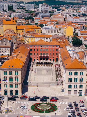 Aerial view of the red neo Renaissance buildings of Republic Square with orange rooftops and a fountain in Split Split Dalmatia County Croatia. Aerial view of the red neo Renaissance buildings of Republic Square with orange rooftops and a fountain in Split Split Dalmatia County Croatia.