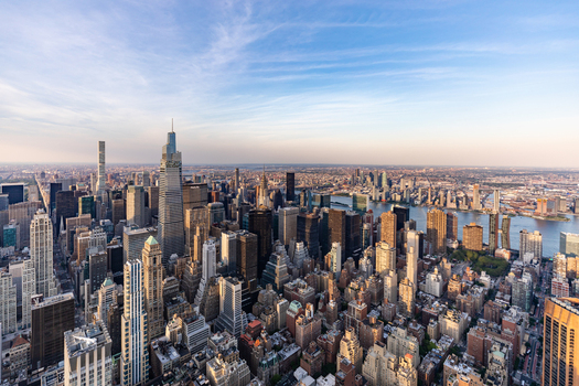 New York United States 09 August 2021 Aerial view of the New York City skyline featuring One Vanderbilt and the Chrysler Building amidst dense urban architecture under a clear blue sky.
