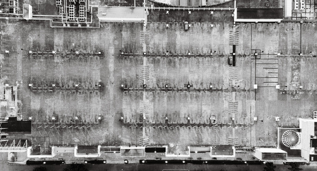 Aerial view of a large rooftop parking lot with marked spaces ventilation units and structural details in Santo Domingo Dominican Republic. Aerial view of a large rooftop parking lot with marked spaces ventilation units and structural details in Santo Domingo Dominican Republic.