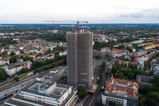 Aerial view of Steglitzer Kreisel skyscraper under renovation surrounded by urban cityscape roads and green spaces in Berlin Berlin Germany. Aerial view of Steglitzer Kreisel skyscraper under renovation surrounded by urban cityscape roads and green spaces in Berlin Berlin Germany.