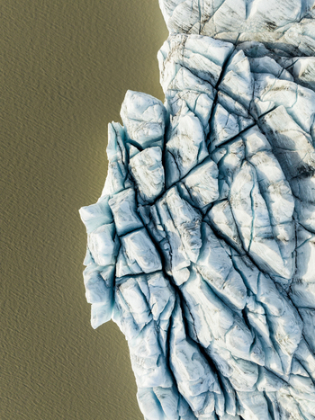 Aerial view of the fractured glacier ice meeting the placid muddy waters creating a striking contrast of textures and hues Fjallsarlon Iceland. Aerial view of the fractured glacier ice meeting the placid muddy waters creating a striking contrast of textures and hues Fjallsarlon Iceland.