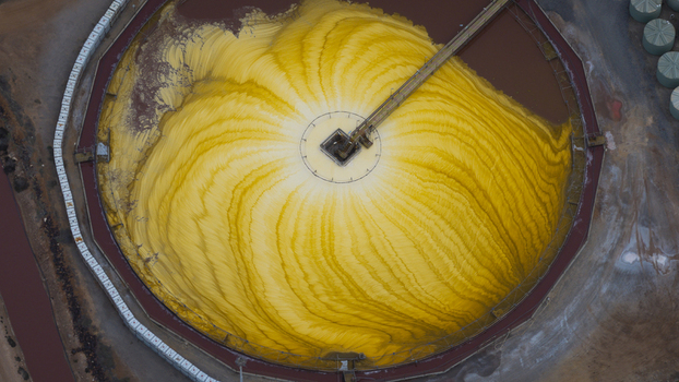Aerial view of a large circular industrial salt storage facility with vibrant yellow salt mounds and a central conveyor system in Kalbarri Western Australia Australia. Aerial view of a large circular industrial salt storage facility with vibrant yellow salt mounds and a central conveyor system in Kalbarri Western Australia Australia.