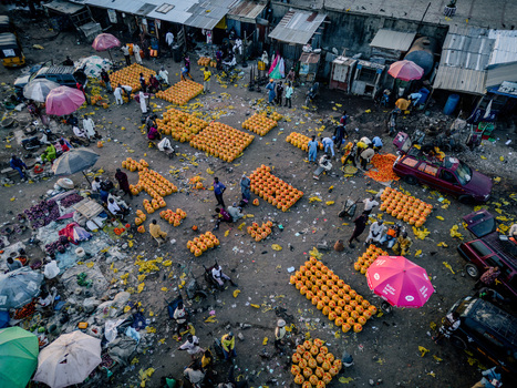 Aerial view of Panteka Market with vendors and rows of yellow containers among people and colorful umbrellas in a busy trading area in Kaduna Kaduna Nigeria. Aerial view of Panteka Market with vendors and rows of yellow containers among people and colorful umbrellas in a busy trading area in Kaduna Kaduna Nigeria.