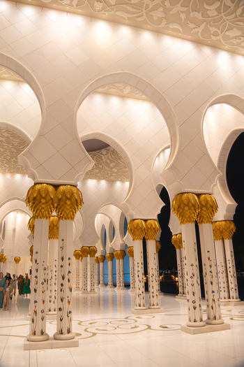 View of the ornate white marble arches and gold capped columns with floral mosaics at the Sheikh Zayed Grand Mosque in Abu Dhabi Abu Dhabi United Arab Emirates. View of the ornate white marble arches and gold capped columns with floral mosaics at the Sheikh Zayed Grand Mosque in Abu Dhabi Abu Dhabi United Arab Emirates.