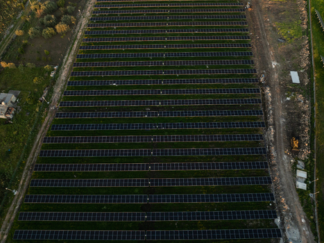 Aerial view of a large solar panel array arranged in neat rows on a green field surrounded by trees in Augusta Sicily Italy. Aerial view of a large solar panel array arranged in neat rows on a green field surrounded by trees in Augusta Sicily Italy.