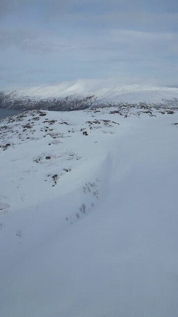 Aerial view of the snowy mountains of Kvaloya island Norway.