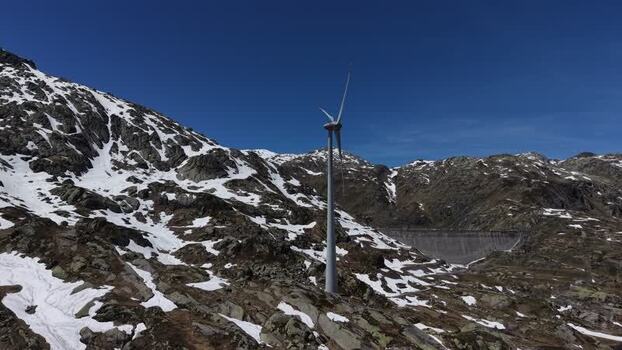 Aerial view of a wind turbine in the snowy mountains Switzerland. Aerial view of a wind turbine in the snowy mountains Switzerland.