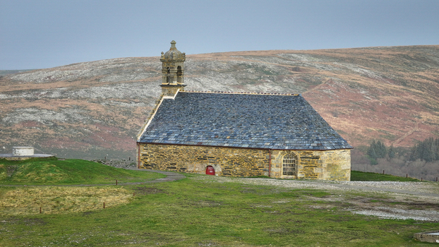 Aerial view of Mont Saint Michel de Brasparts chapel with its stone walls and slate roof overlooking the rolling hills of the Arree Mountains Saint Rivoal Bretagne France. Aerial view of Mont Saint Michel de Brasparts chapel with its stone walls and slate roof overlooking the rolling hills of the Arree Mountains Saint Rivoal Bretagne France.