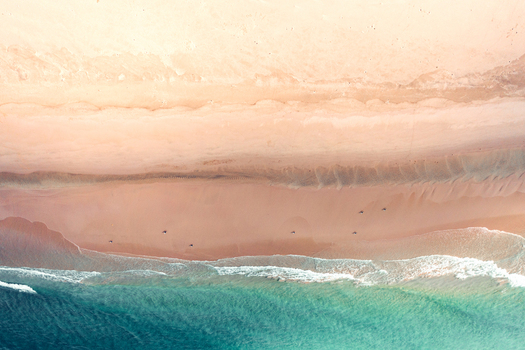 Aerial view of the turquoise ocean waves washing onto the pristine sandy shore of Detwah Lagoon in Qalansiyah wa Abd Al Kuri Socotra Yemen. Aerial view of the turquoise ocean waves washing onto the pristine sandy shore of Detwah Lagoon in Qalansiyah wa Abd Al Kuri Socotra Yemen.