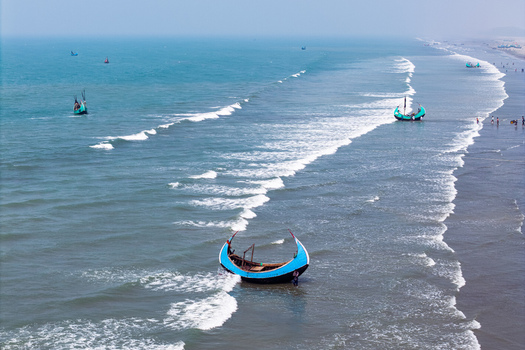Cox s Bazar Bangladesh 10 March 2026 Aerial view of traditional moon shaped fishing boats called Sampans floating in the turquoise sea and resting on the sandy shore with waves breaking. Cox s Bazar Bangladesh 10 March 2026 Aerial view of traditional moon shaped fishing boats called Sampans floating in the turquoise sea and resting on the sandy shore with waves breaking.