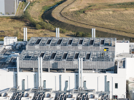 Aerial view of Vantage Data Centers BER1 facility featuring industrial cooling systems on the roof white exterior walls and surrounding landscape in Ludwigsfelde Brandenburg Germany. Aerial view of Vantage Data Centers BER1 facility featuring industrial cooling systems on the roof white exterior walls and surrounding landscape in Ludwigsfelde Brandenburg Germany.