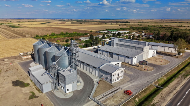 Aerial view of storage silo Bavaniste with metal grain bins and industrial buildings surrounded by agricultural fields under a clear blue sky in Bavaniste Vojvodina Serbia.