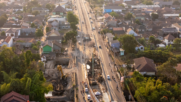 Indonesia 24 September 2026 Aerial view of a road construction site with excavators and heavy machinery on a street surrounded by residential houses and trees in Indonesia.