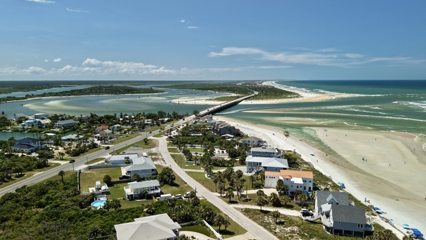 Aerial view of Matanzas Inlet showing the bridge coastal homes sandy beaches and turquoise waters in St. Johns County Florida United States. Aerial view of Matanzas Inlet showing the bridge coastal homes sandy beaches and turquoise waters in St. Johns County Florida United States.