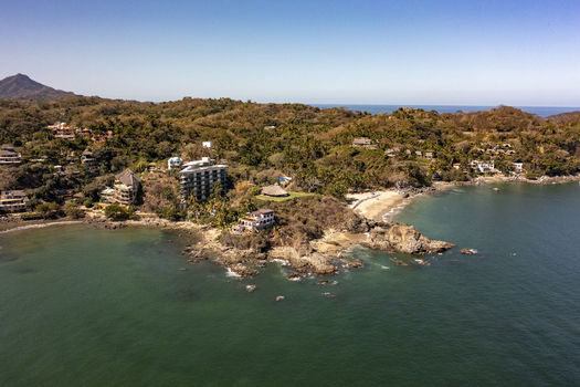 Aerial view of the coastal landscape of Sayulita featuring rocky cliffs sandy beaches lush vegetation and hillside buildings overlooking the Pacific Ocean in Sayulita Nayarit Mexico. Aerial view of the coastal landscape of Sayulita featuring rocky cliffs sandy beaches lush vegetation and hillside buildings overlooking the Pacific Ocean in Sayulita Nayarit Mexico.