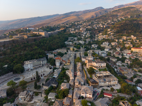 Aerial view of Gjirokaster Castle overlooking the historic stone houses and narrow streets of the old town in Gjirokaster Gjirokaster County Albania. Aerial view of Gjirokaster Castle overlooking the historic stone houses and narrow streets of the old town in Gjirokaster Gjirokaster County Albania.
