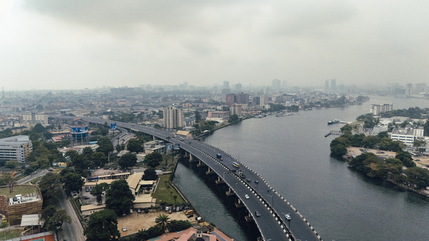Aerial view of Lagos Island featuring the bridge over the lagoon with urban buildings and hazy sky in Lagos Lagos Nigeria. Aerial view of Lagos Island featuring the bridge over the lagoon with urban buildings and hazy sky in Lagos Lagos Nigeria.