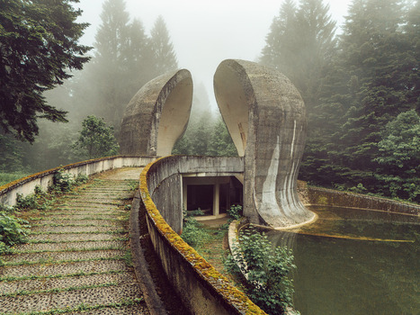 View of the Korcanica Memorial Zone monument with curved concrete wings and stone paths in a foggy pine forest in Sanski Most Federation of Bosnia Bosnia and Herzegovina. View of the Korcanica Memorial Zone monument with curved concrete wings and stone paths in a foggy pine forest in Sanski Most Federation of Bosnia Bosnia and Herzegovina.