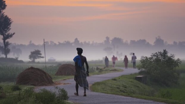 View of people walking on a winding rural road at dawn Bangladesh. View of people walking on a winding rural road at dawn Bangladesh.